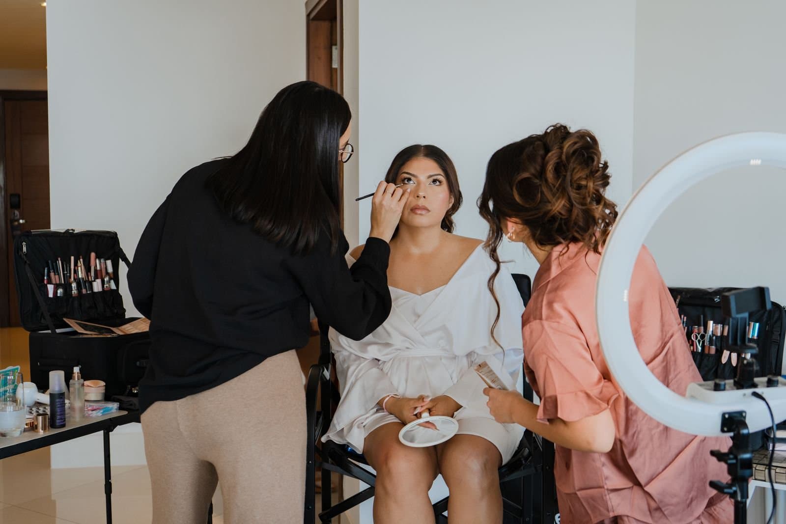 Dos artistas de Mich & Beauty trabajando con una novia a la vez