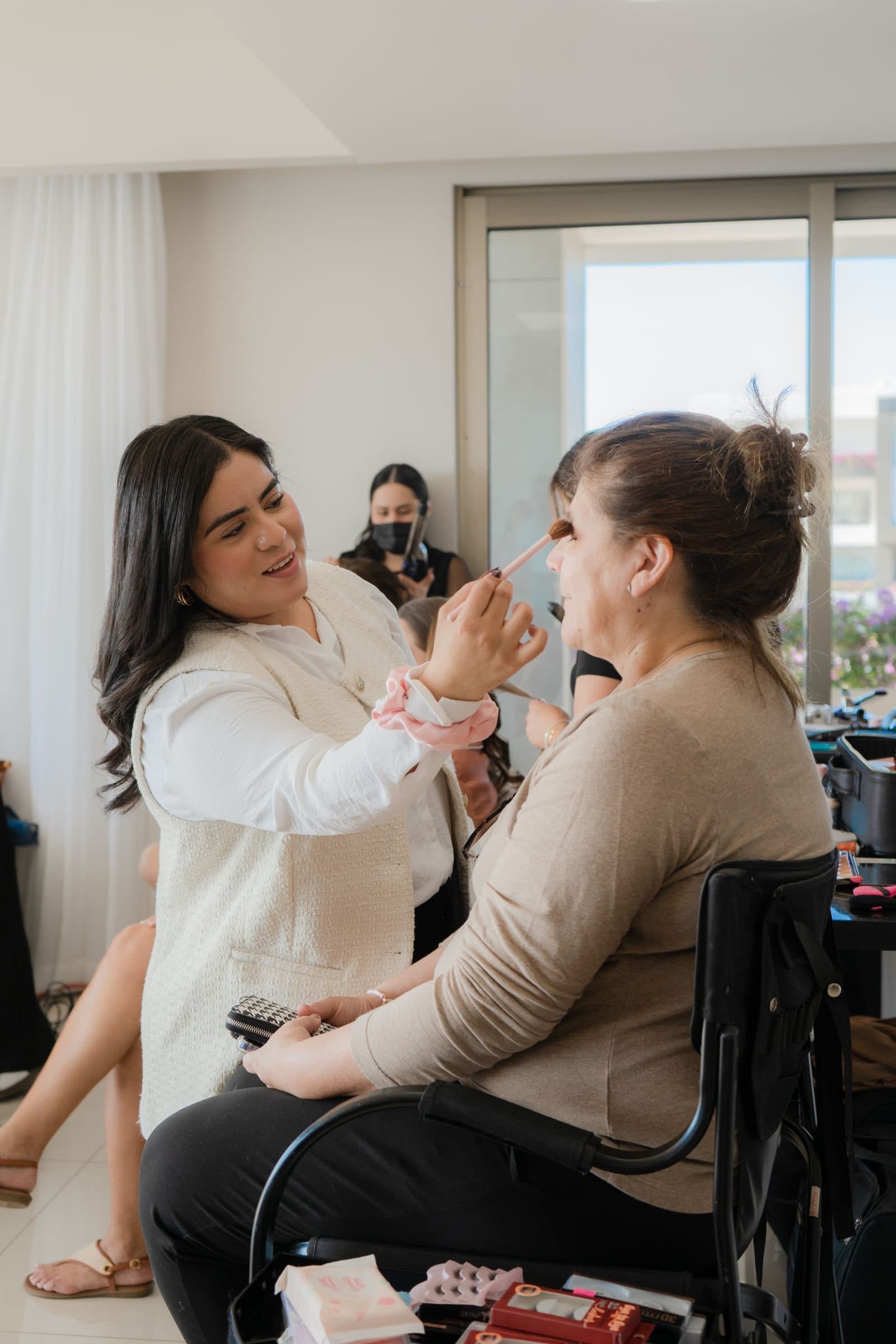 Artista de Mich & Beauty maquillando a la mamá de la novia