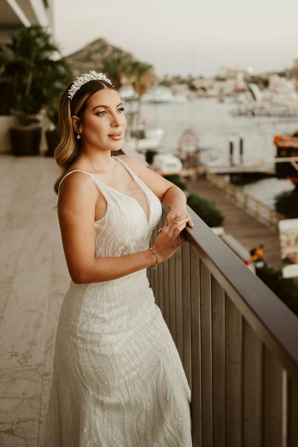 Novia con corona de perlas en un balcón con vista a la marina