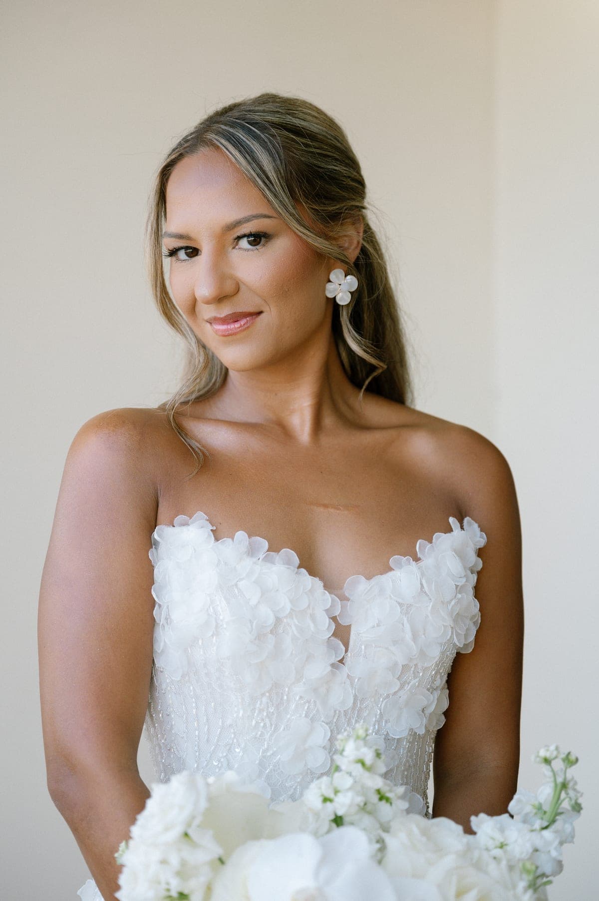 Novia con vestido strapless de flores mirando a la cámara