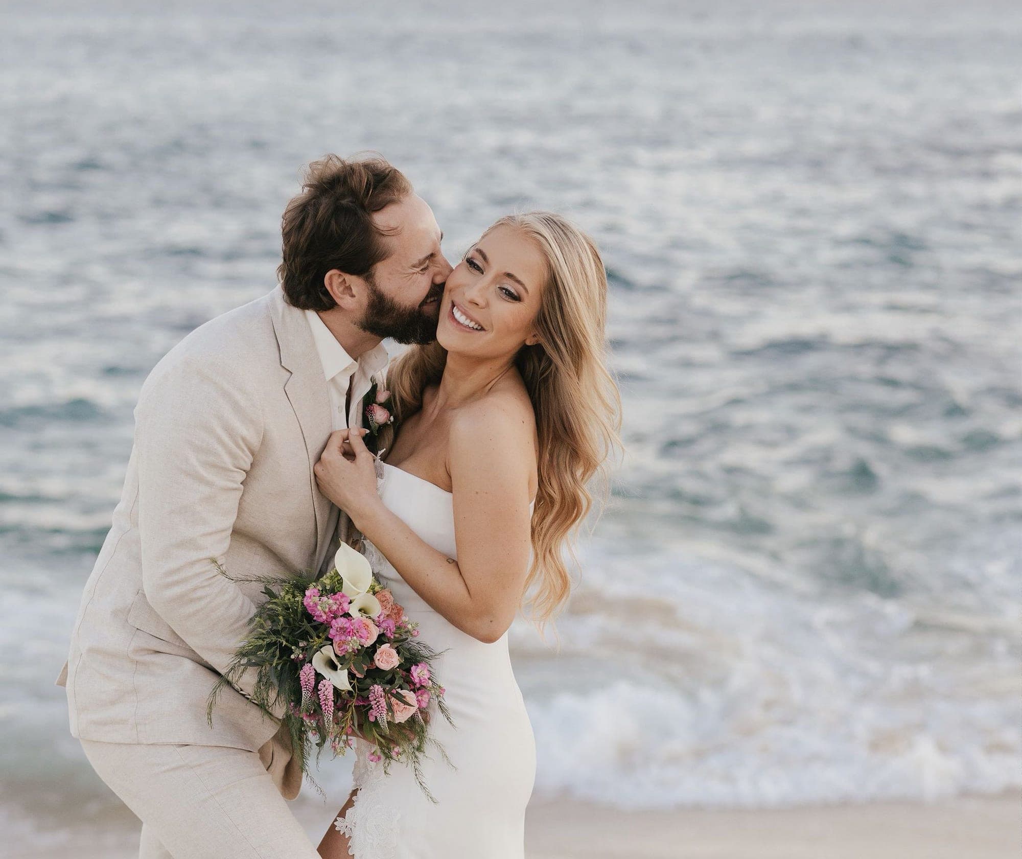 Novios en la playa después de la ceremonia, con peinado y maquillaje de Mich & Beauty Team